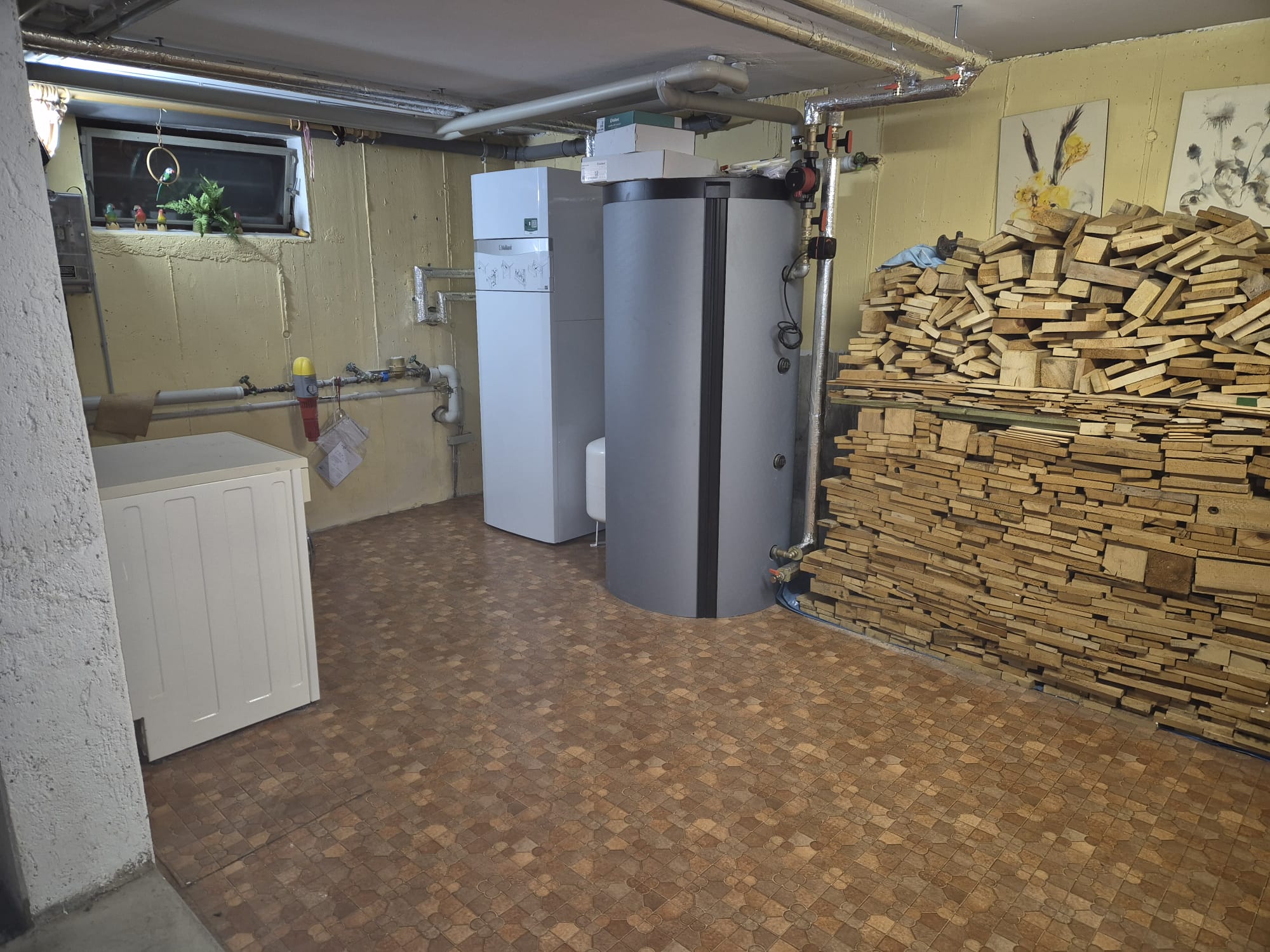 Neue Heiztechnik mit uniTOWER und Speicher neben dem Holzstapel